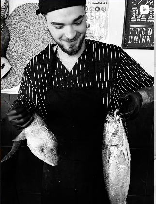 Cocinero de Jarana sosteniendo pescado fresco de lonja